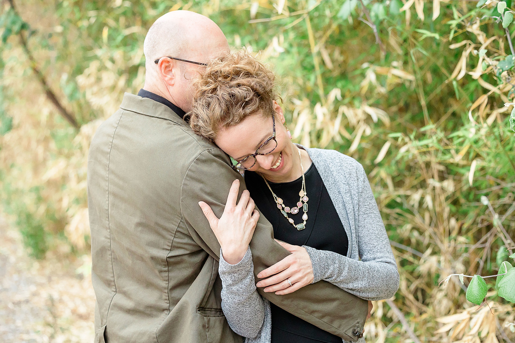 woman leans on man's shoulder during Katy Trail engagement session