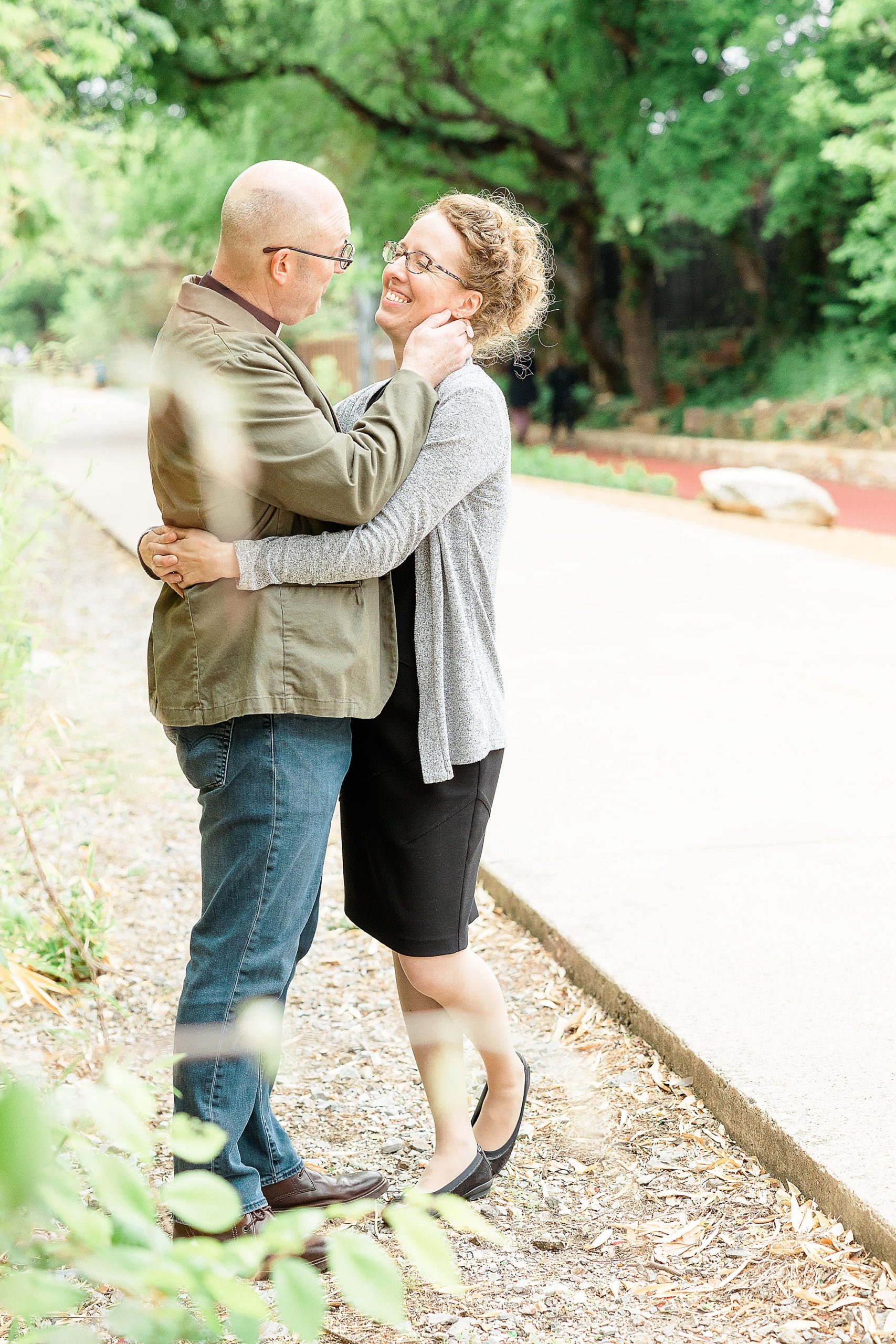 couple hugs along path during Dallas TX engagement photos