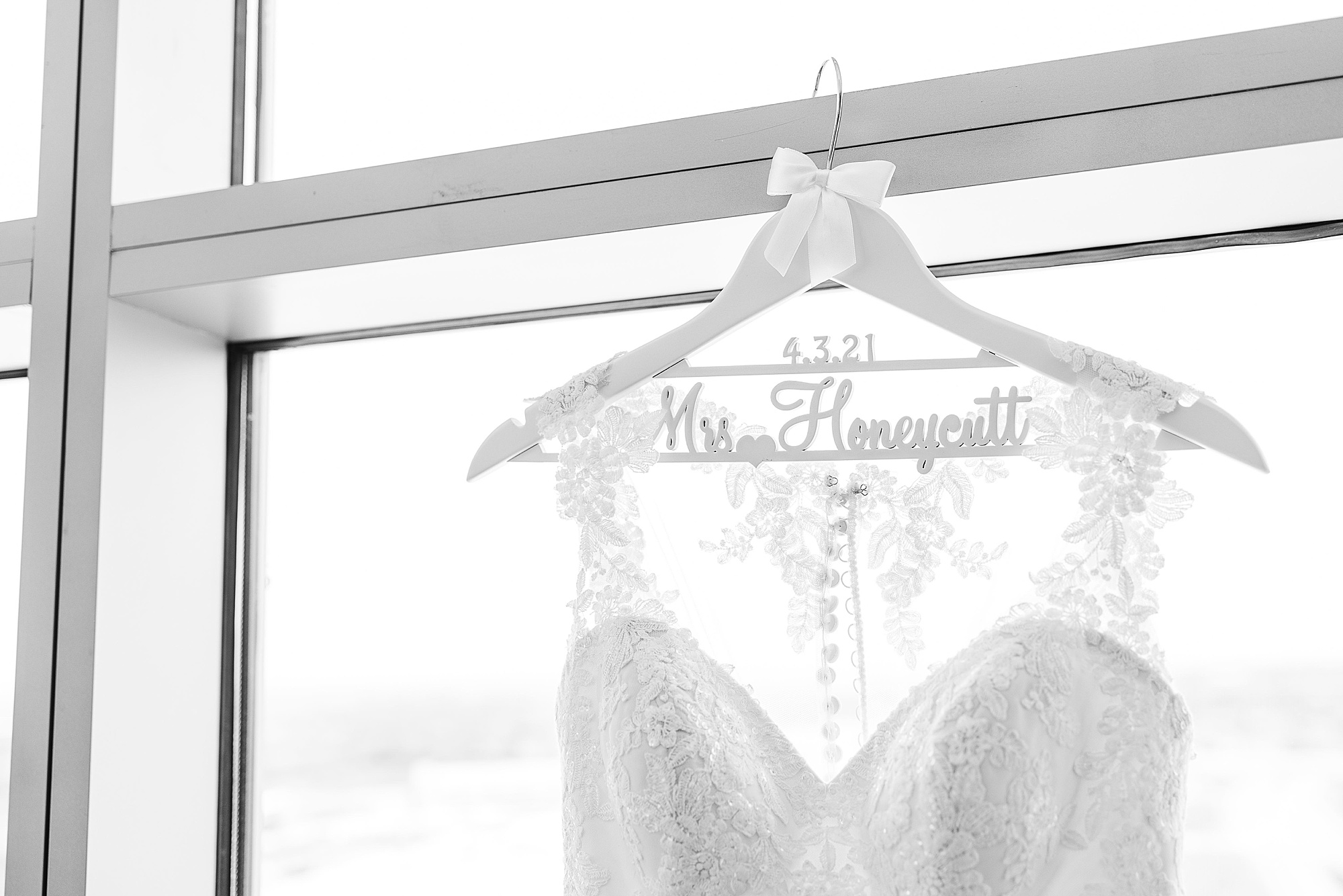 bride's wedding dress hangs in window of Omni Hotel