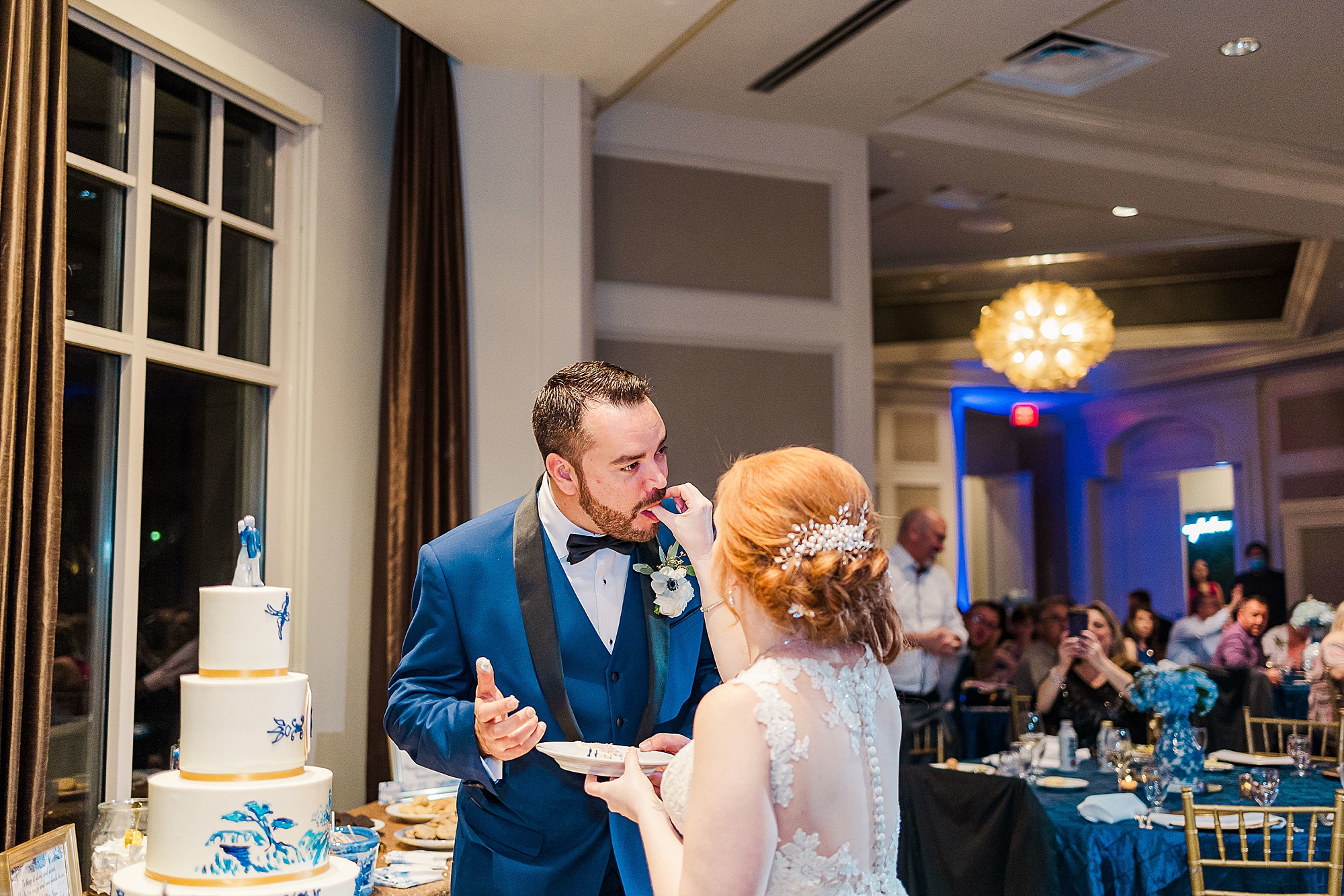 bride feeds groom cake during Frisco TX wedding reception