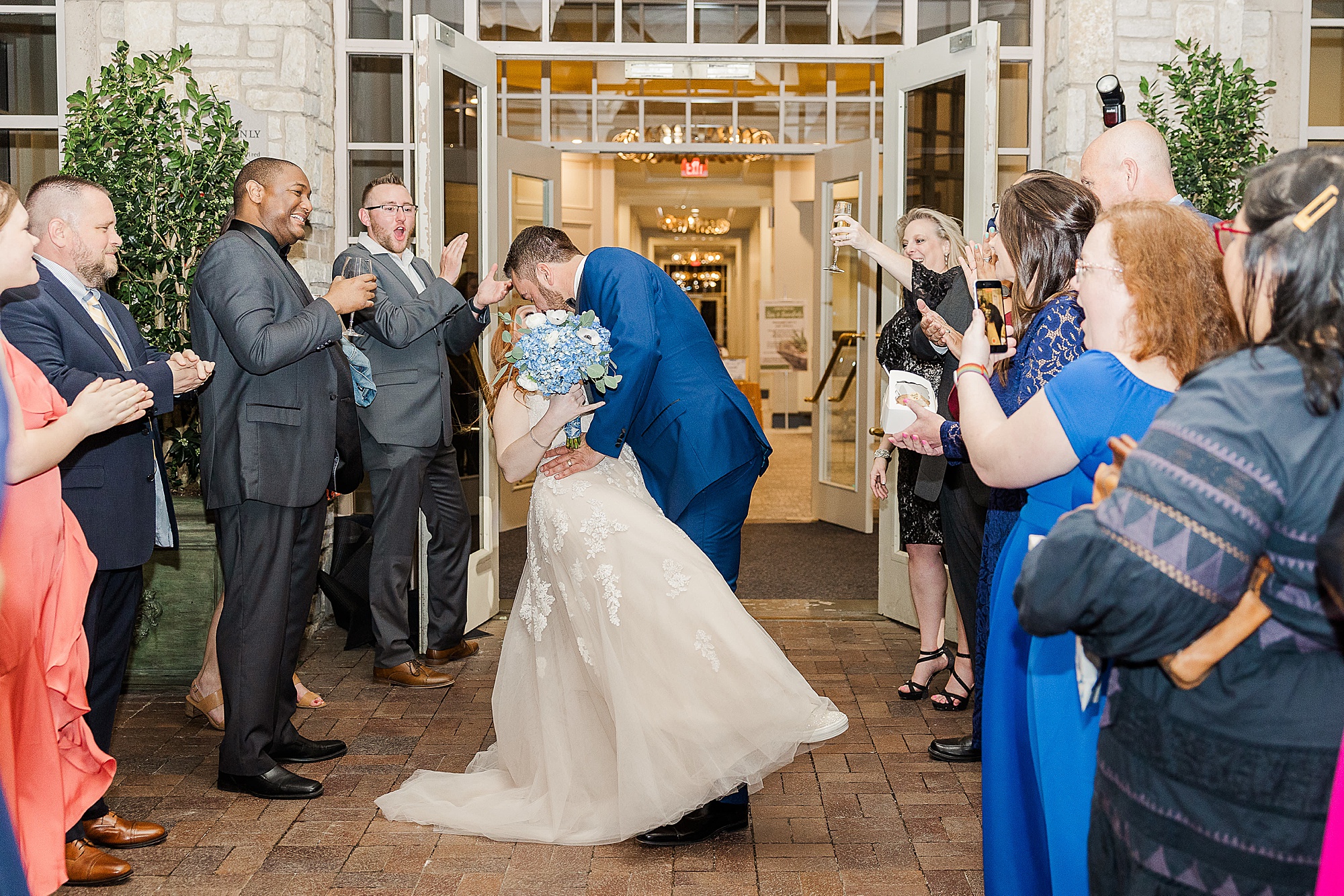 bride and groom kiss during exit from Frisco TX wedding
