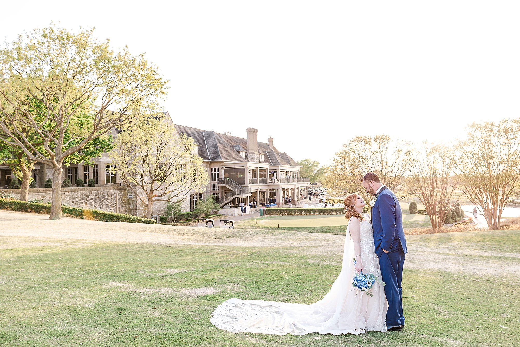 bride and groom kiss in front of Stonebriar Country Club