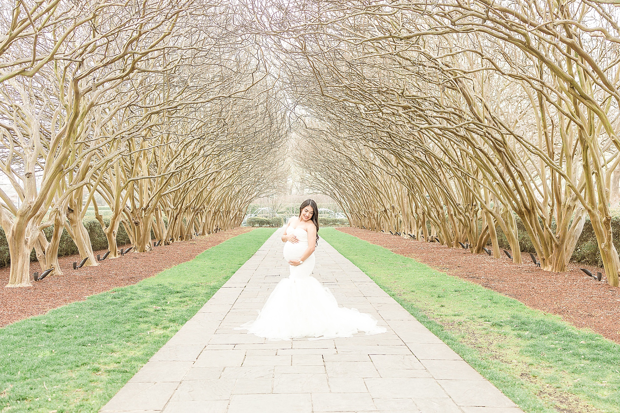 woman poses on walkway of Dallas Arboretum