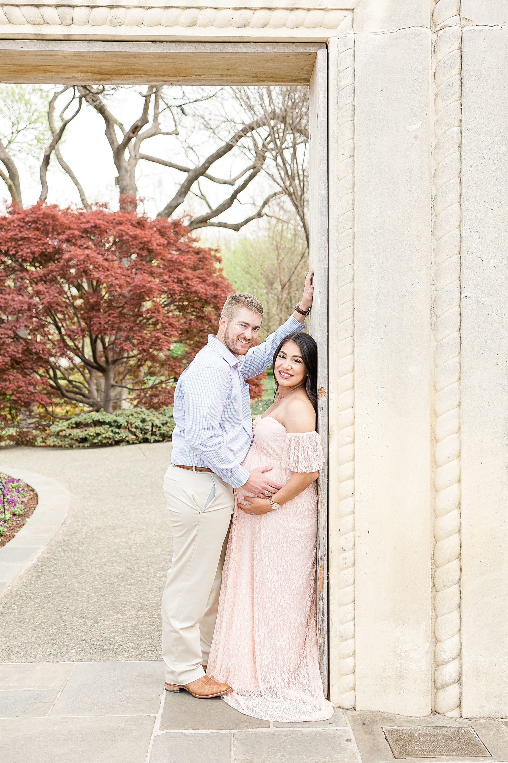 couple poses during spring maternity session at Dallas Arboretum