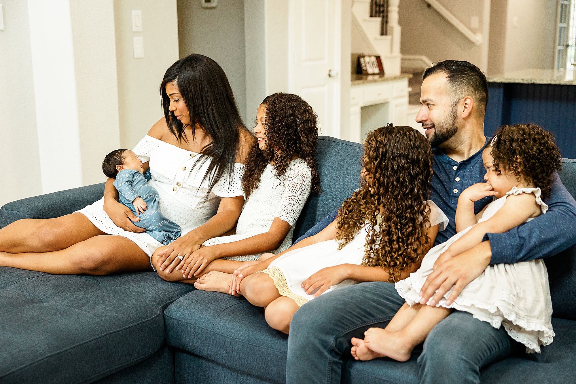 family of five sits on couch at home during Dallas lifestyle newborn session