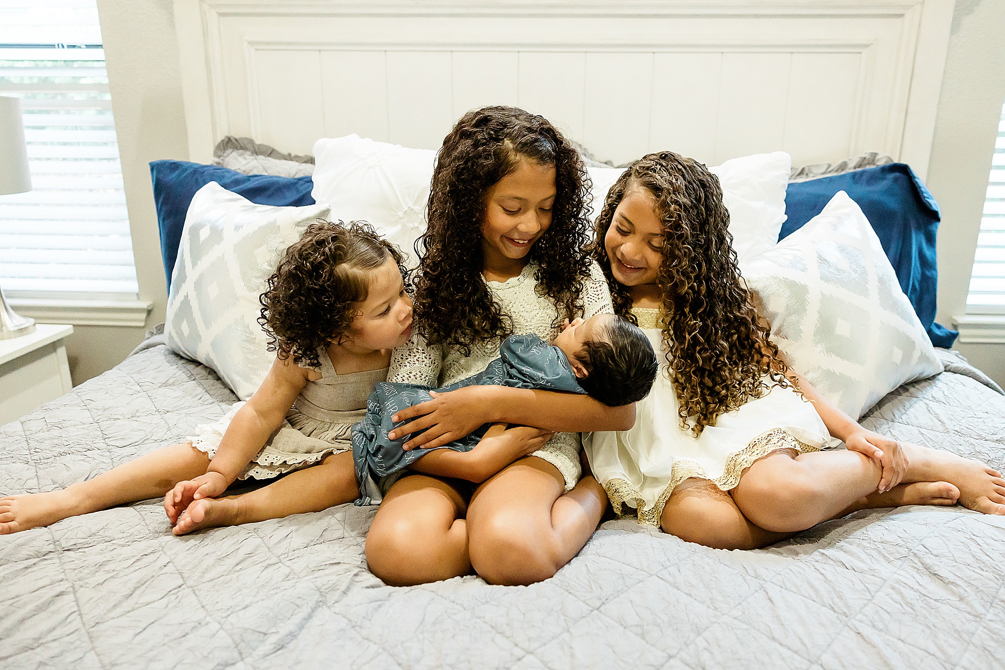 big sisters look at baby brother during Dallas lifestyle newborn session