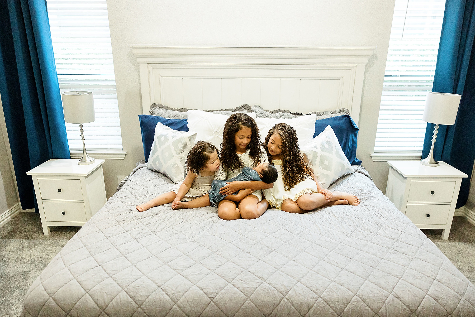 three big sisters hold baby boy during Dallas lifestyle newborn session