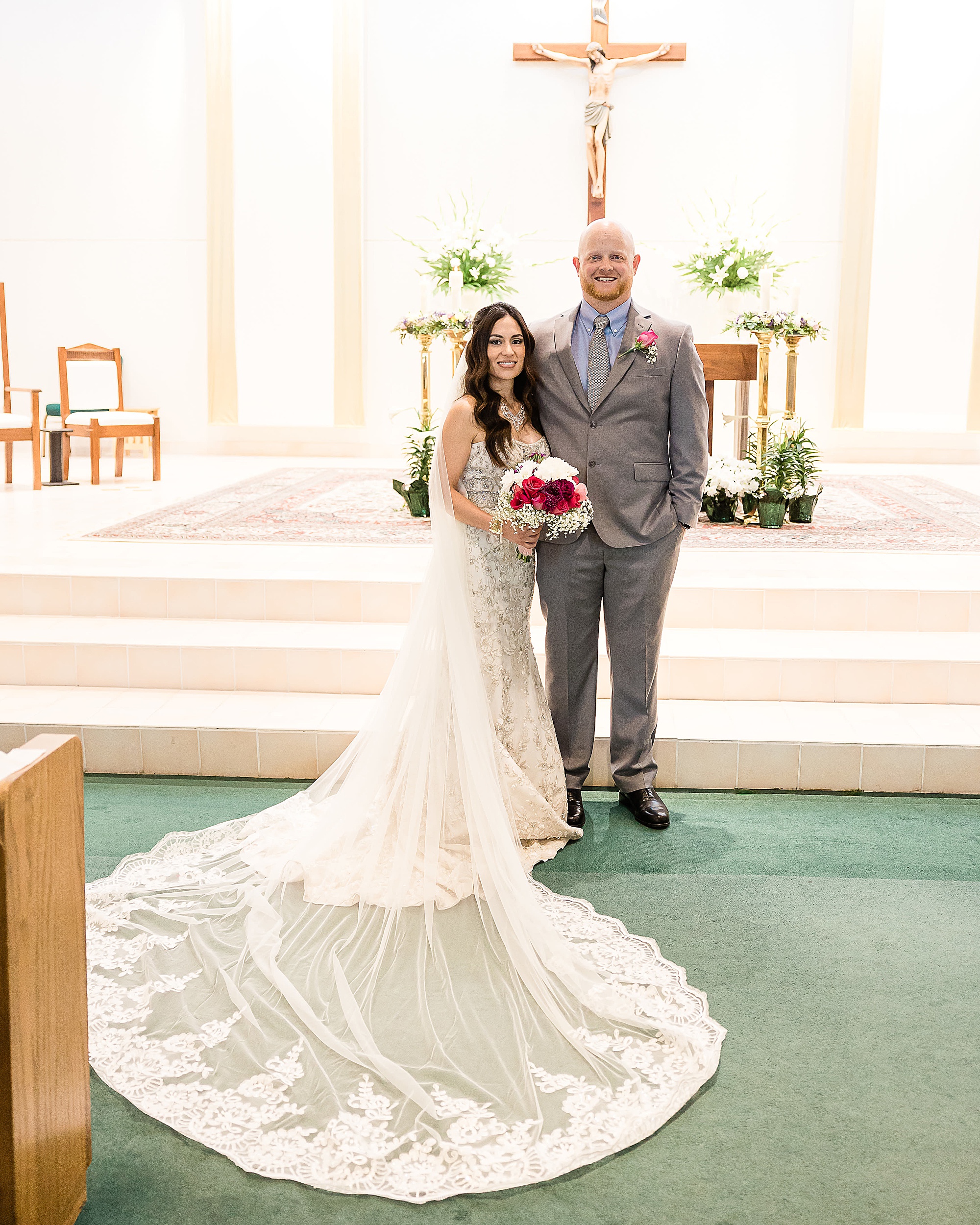 bride and groom pose at altar after vow renewal 