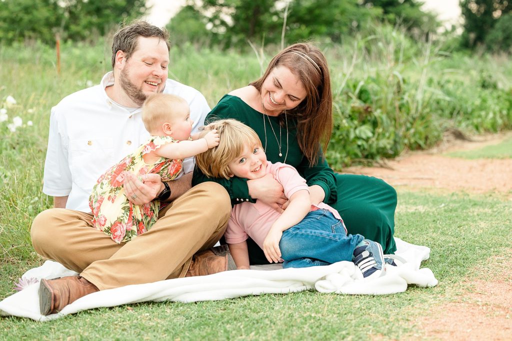 family of four laughs together during Little Elm family portraits with Abbie Road Photography