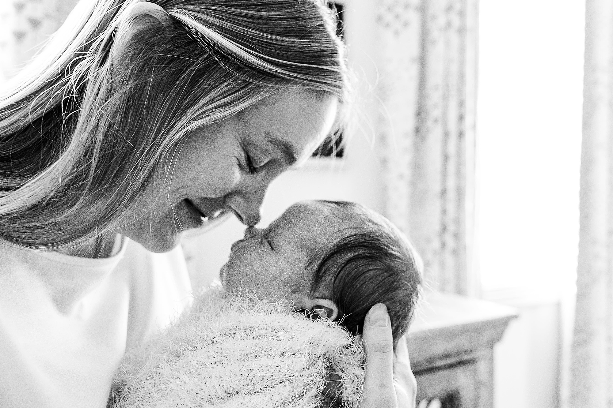 mom nuzzles daughter during Krum lifestyle newborn session