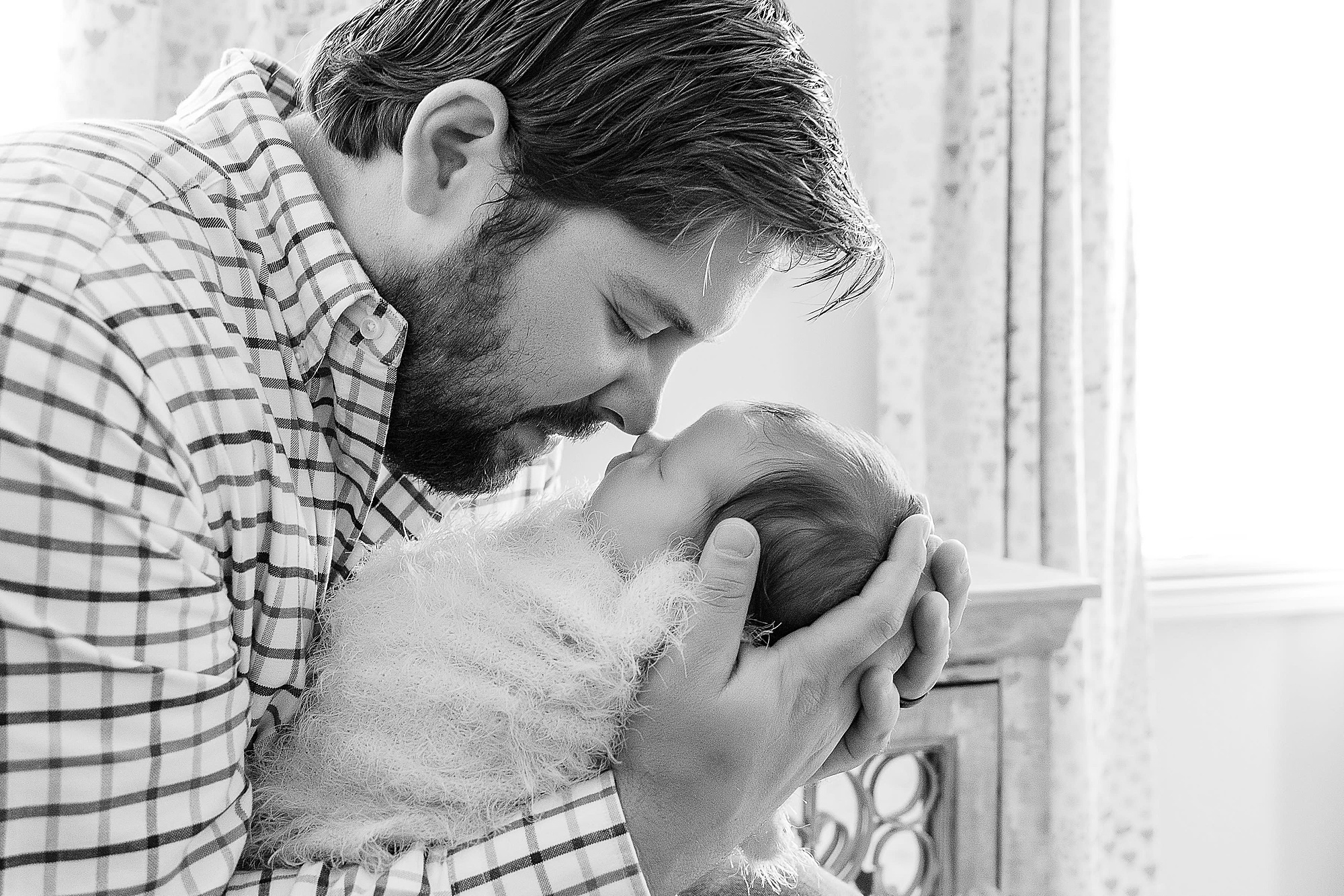 dad touches noses with baby girl during Krum lifestyle newborn session