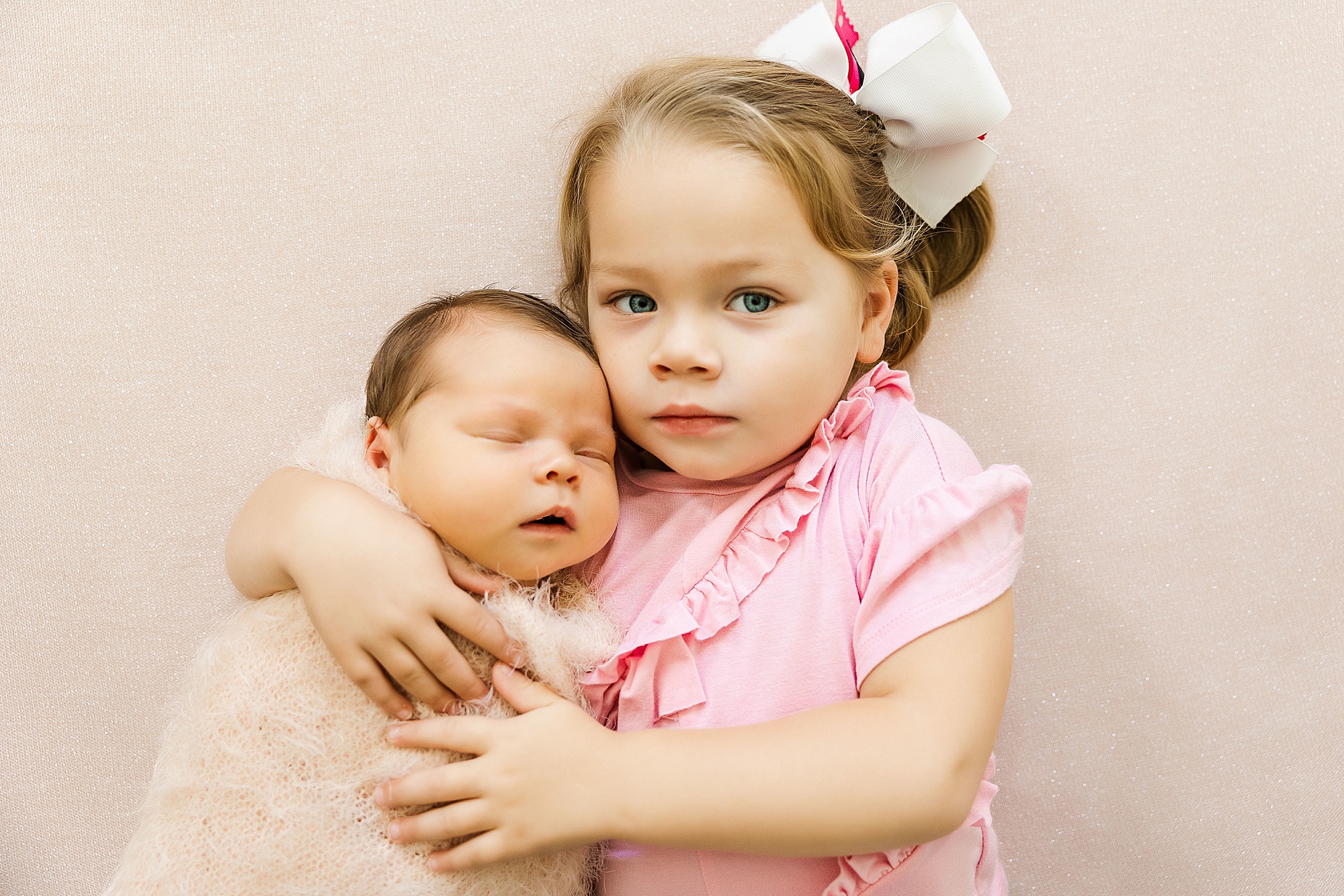 big sister holds new baby during Krum lifestyle newborn session