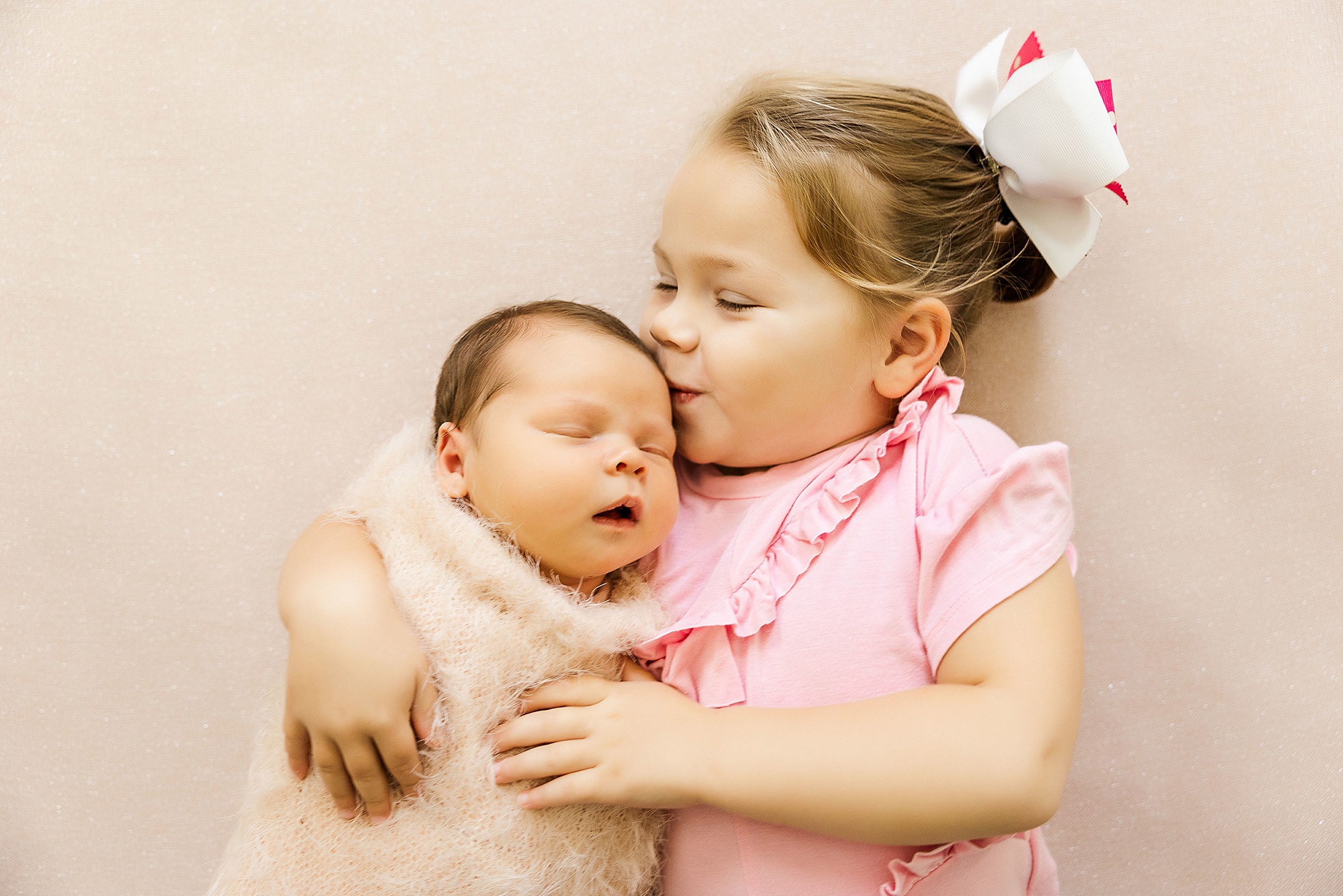 sister kisses new baby during Krum lifestyle newborn session