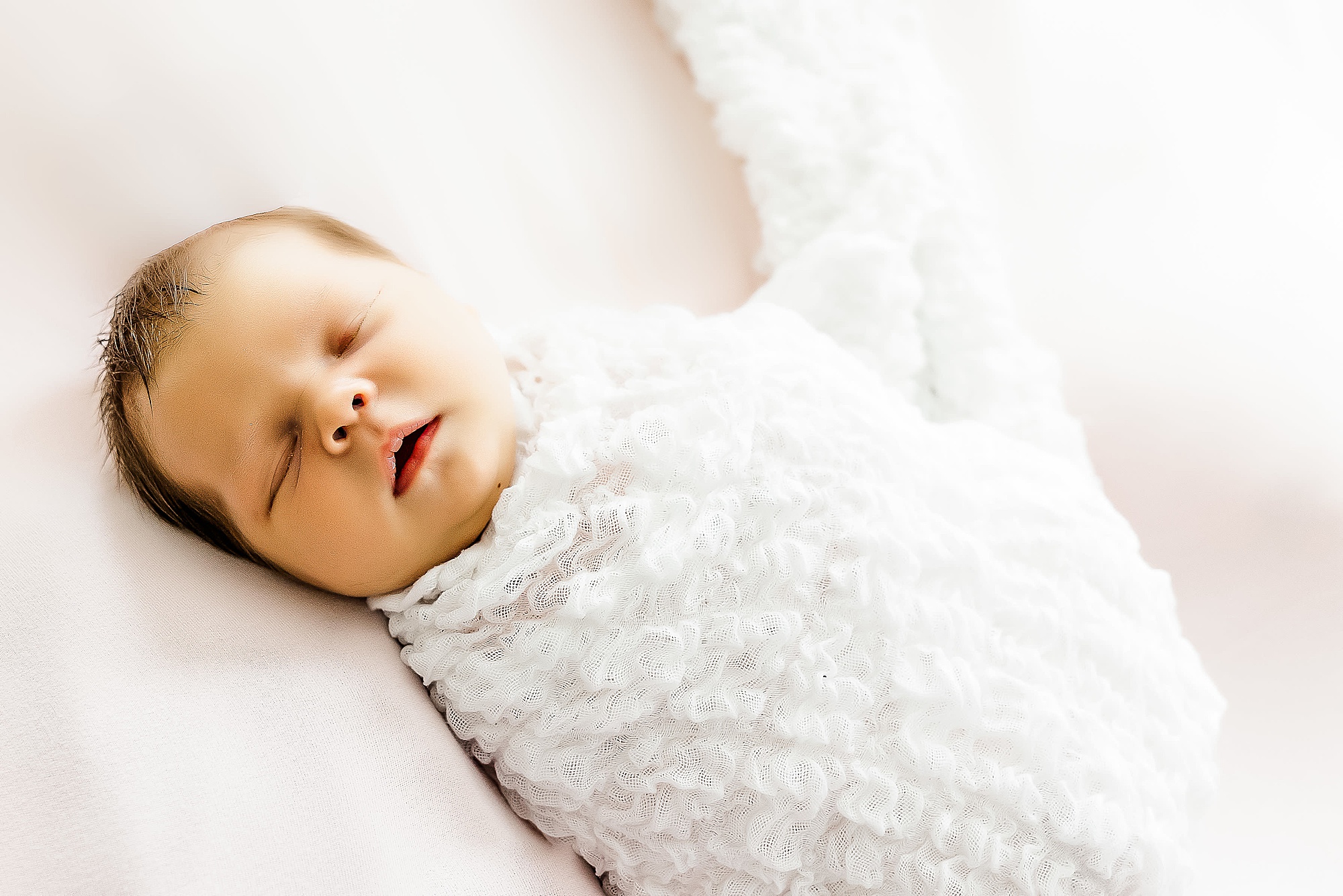 baby in white wrap sleeps during Krum lifestyle newborn session