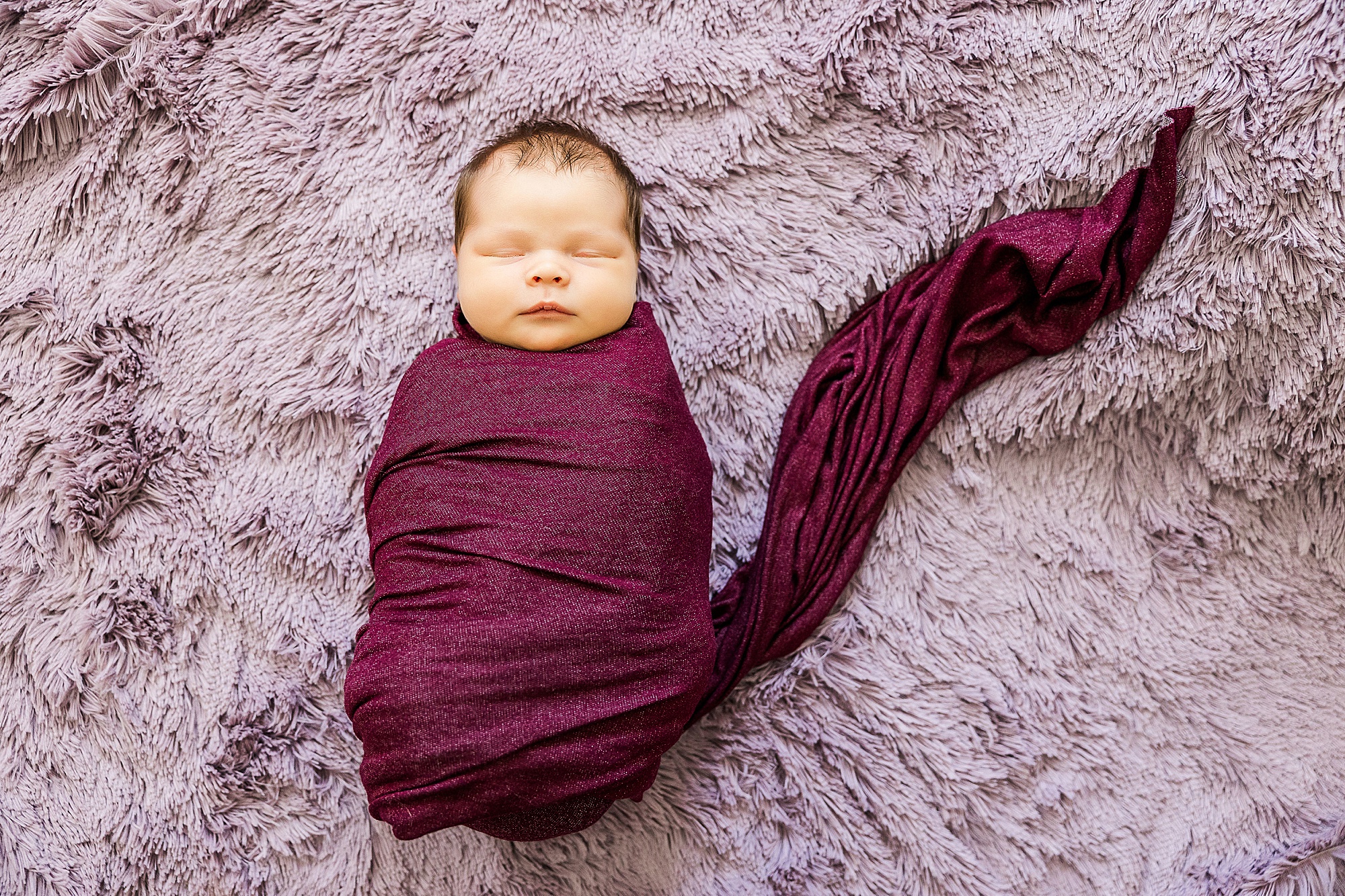 baby in purple wrap sleeps during Krum lifestyle newborn session