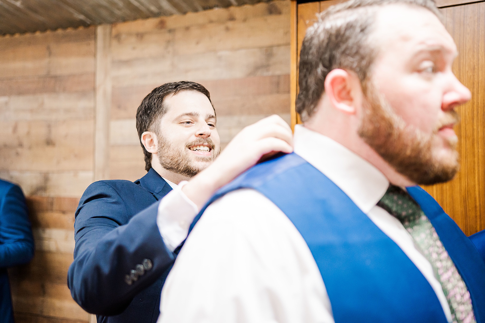 groomsman helps groom with bowtie for Texas wedding