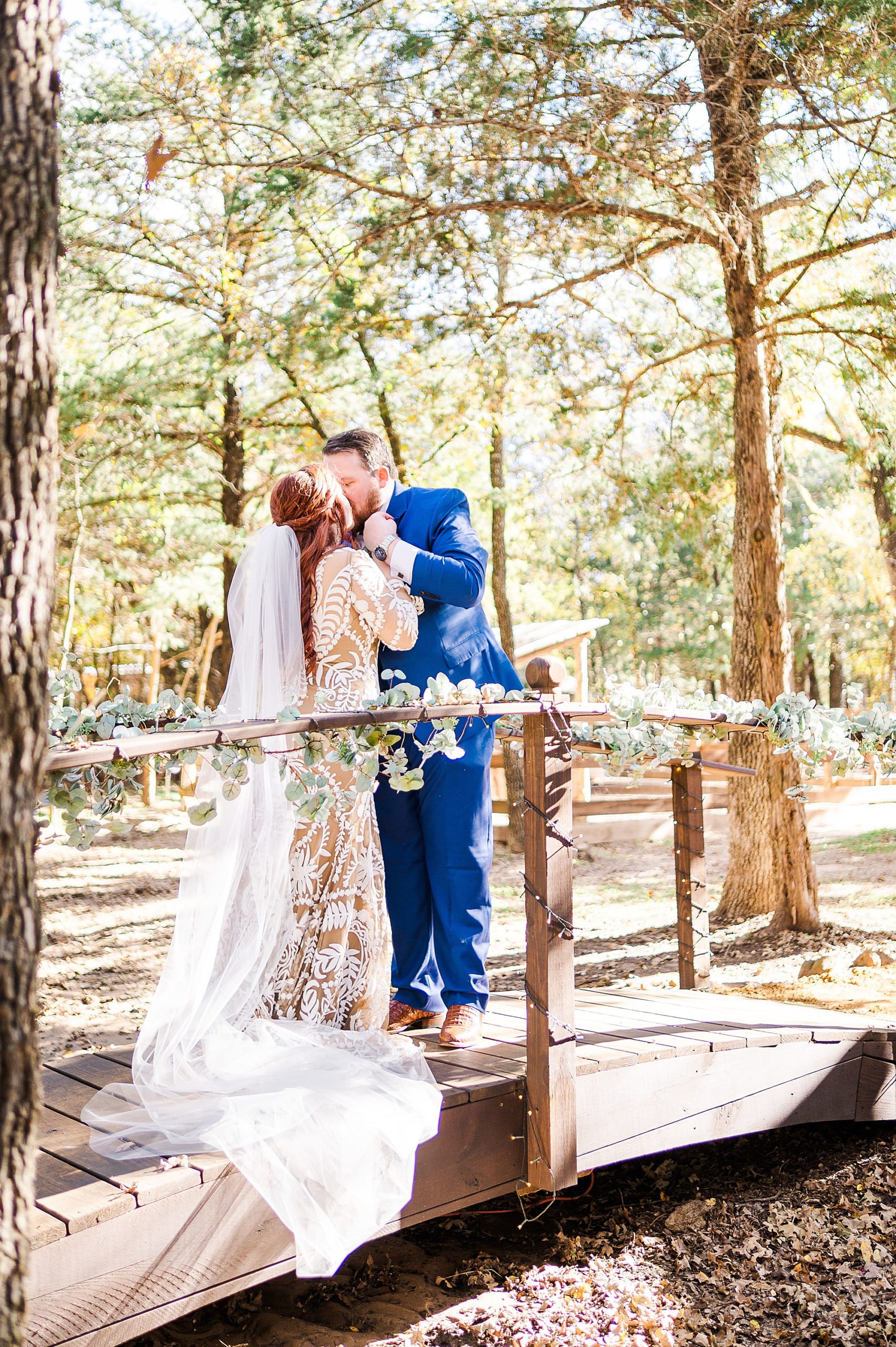 bride and groom kiss on bridge at Oak Meadow Ranch