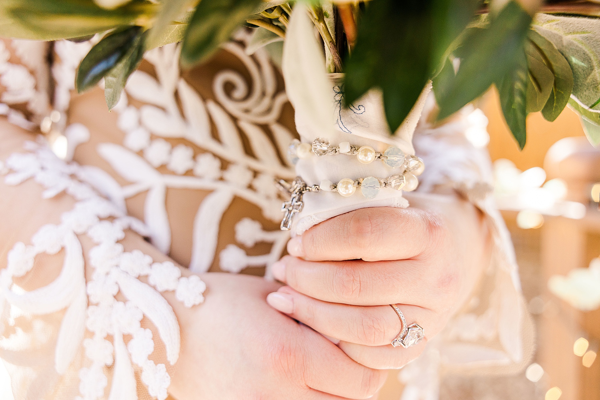 bride holds bouquet with pearls around stems