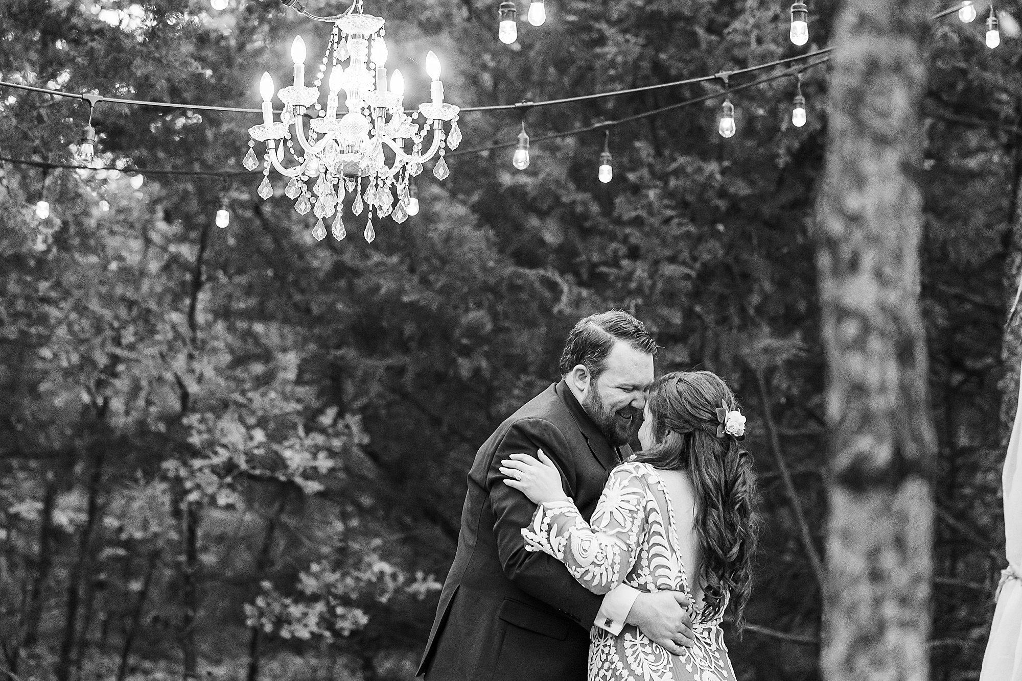bride and groom dance under chandelier outside at Oak Meadow Ranch