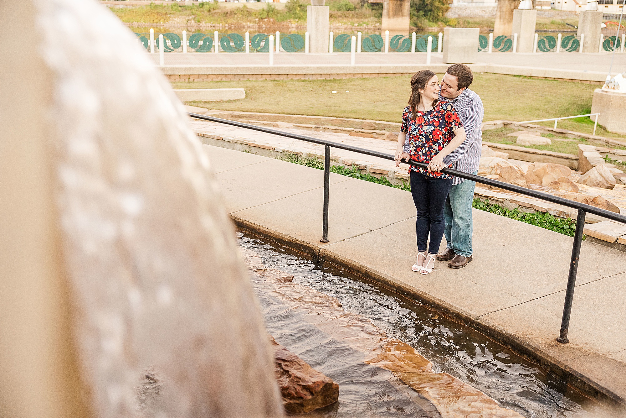 bride and groom pose by fountain in Shreveport LA