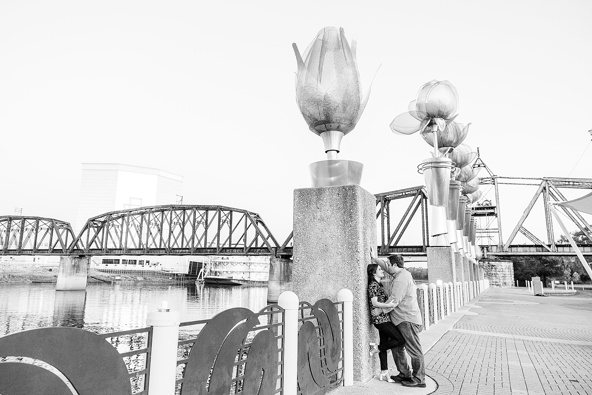 couple poses against pillar of bridge during Shreveport engagement session